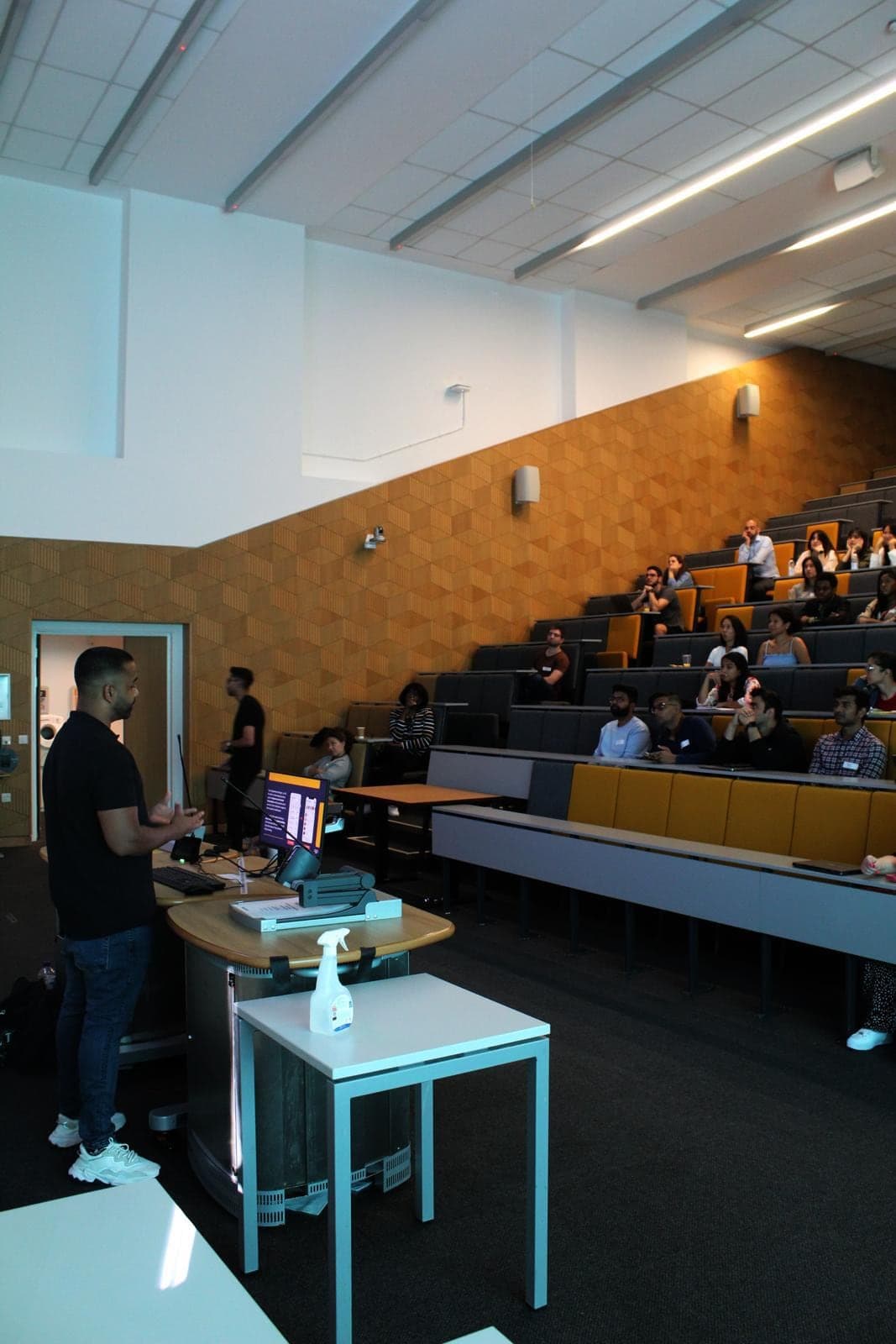 A Digital Influx session in a university lecture theatre, the speaker presenting to a seated audience of students.