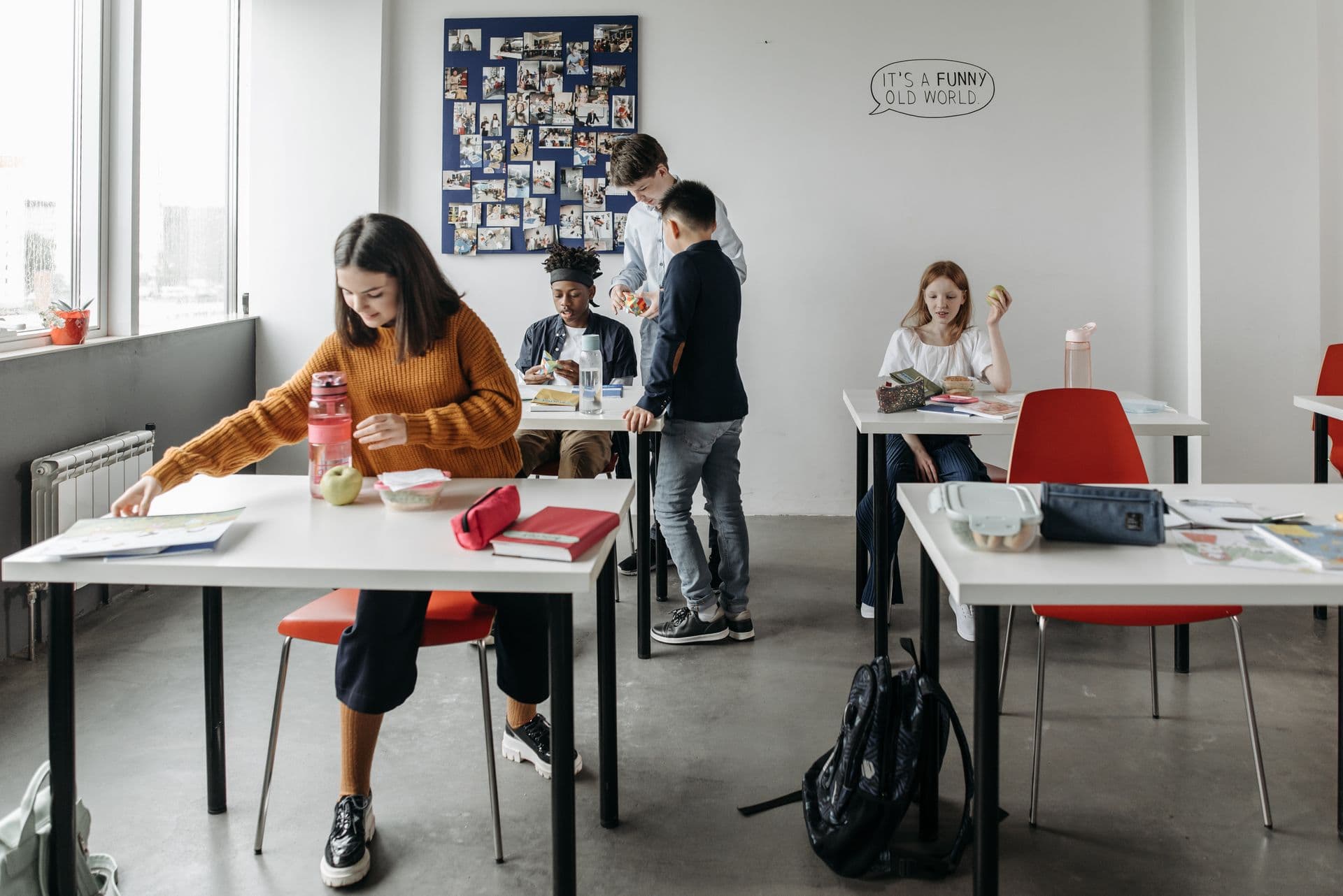 Students working at desks in a bright classroom.