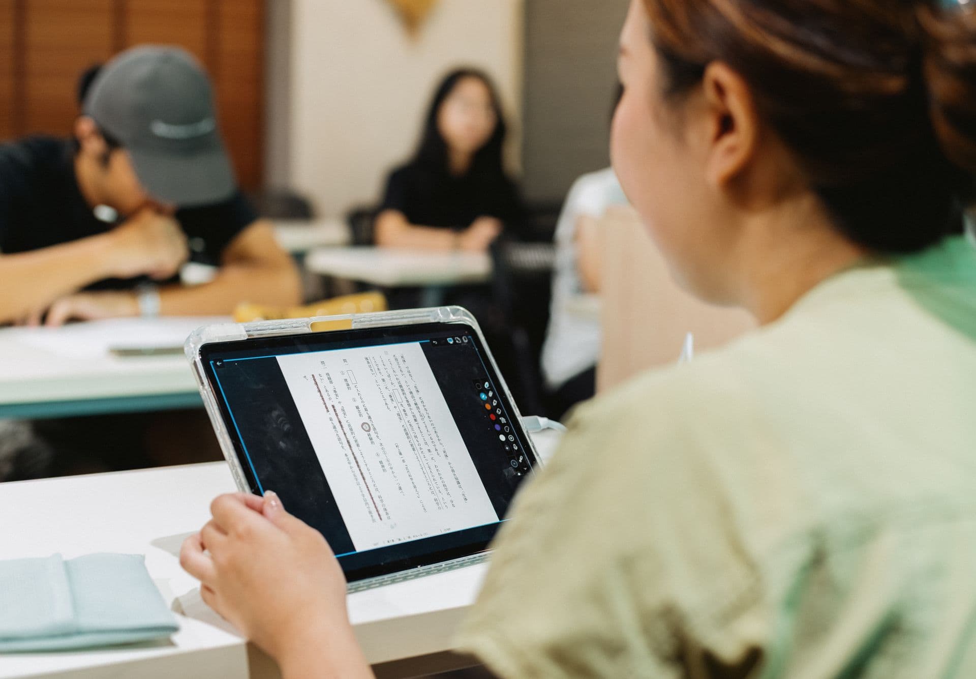 Students using a tablet in a classroom.