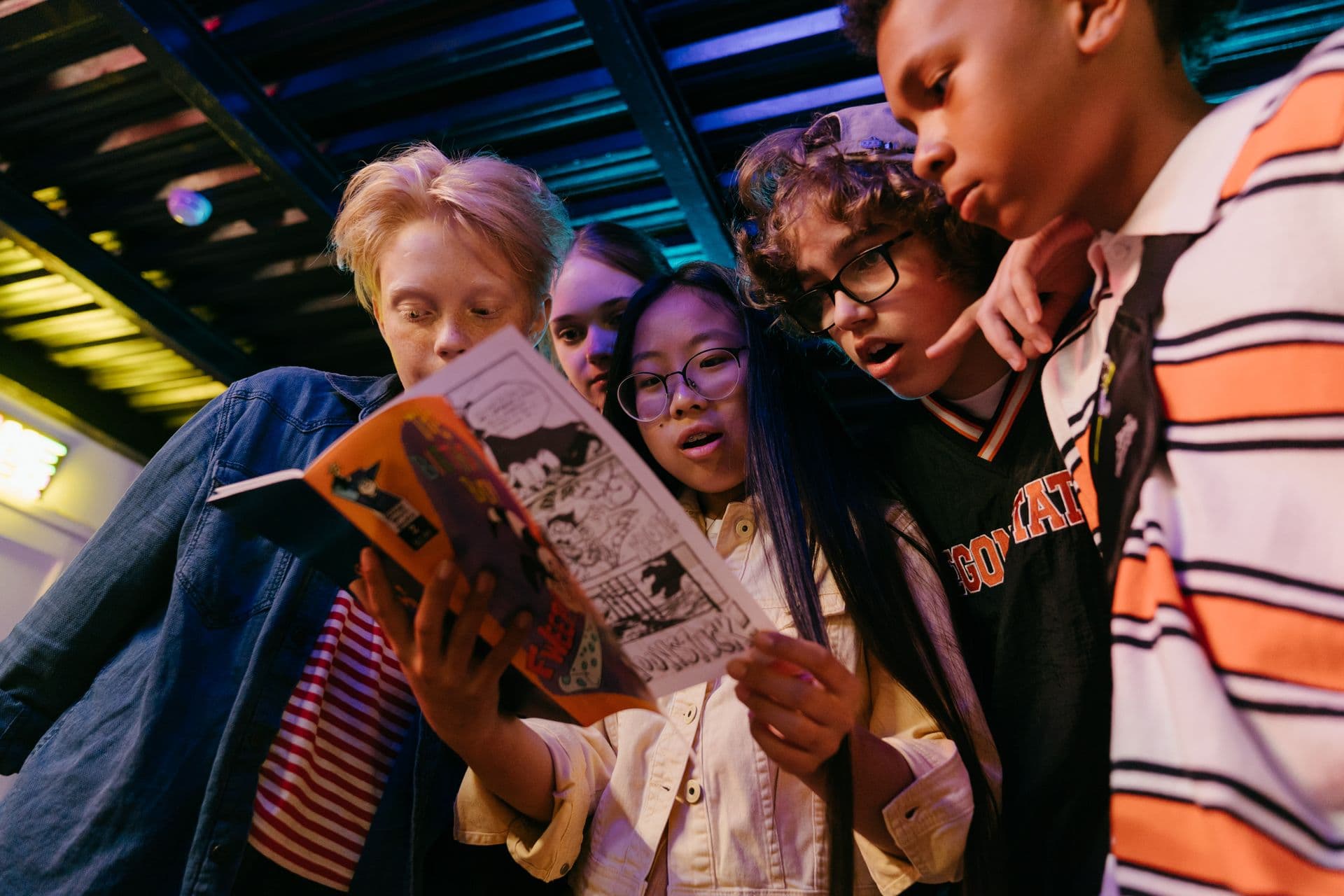 A group of teenagers reading a comic together.